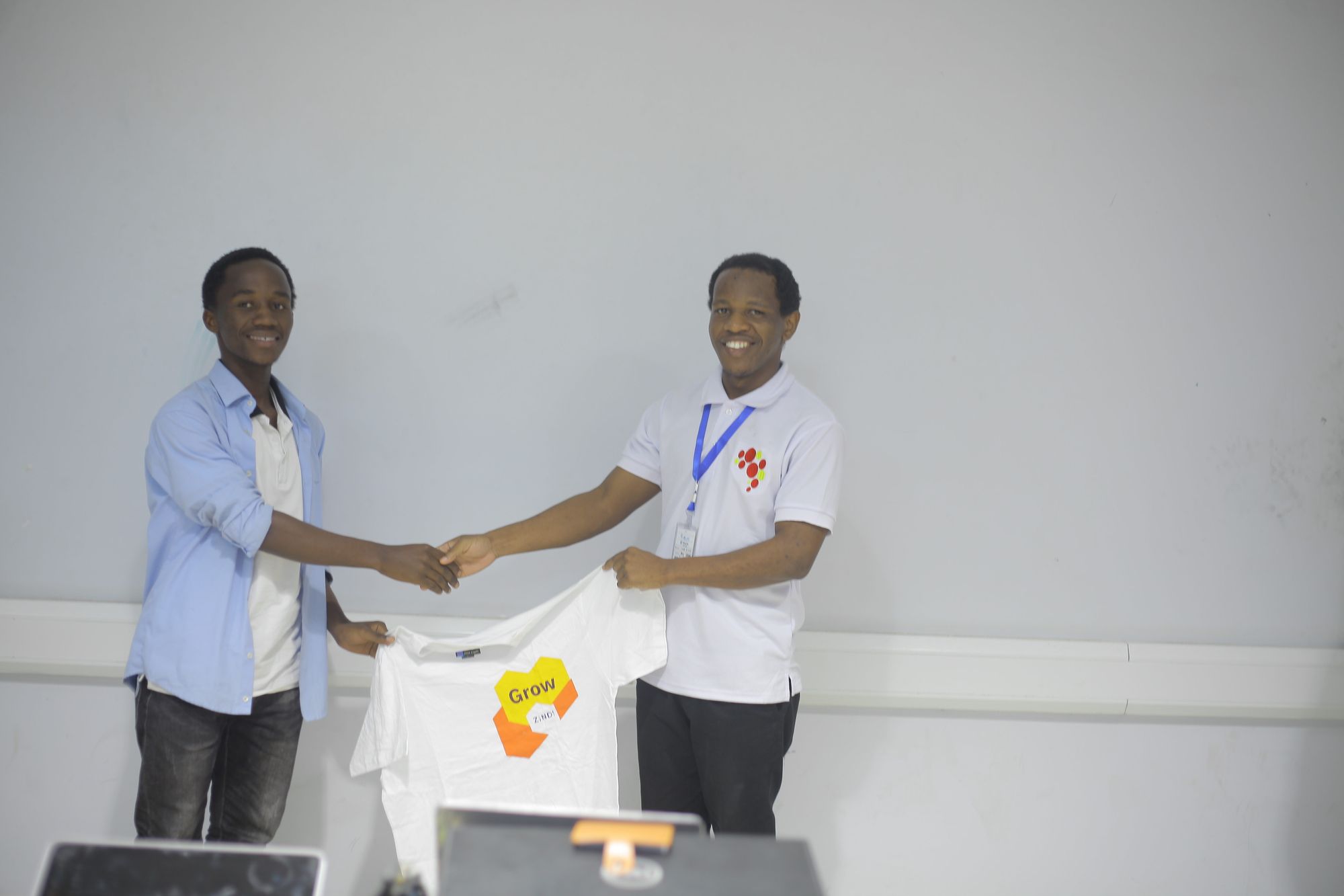 First hackathon winner: Lucas Mghasa, receiving prize (150,000 TZS, Certificate, and T-shirt)